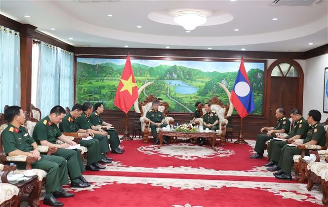越南国防部副部长阮文贤中将礼节性拜见老挝国防部长坎良·奥萨宋。图自越通社