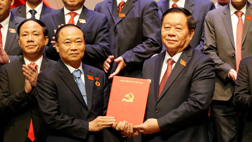 中央宣传与群众工作部部长阮仲义向蔡大玉同志授予决定。图自越通社