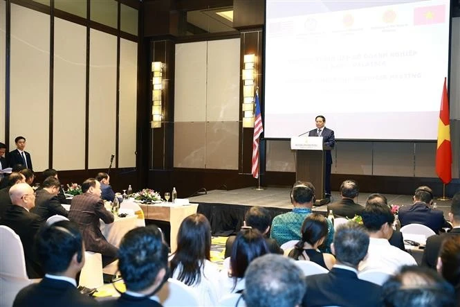 范明政总理在越马企业交流活动上发表讲话。图自越通社