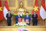 越南政府总理范明政与新加坡总理黄循财共同见证越南友好协会与新加坡国际基金会合作备忘录的签署。图自越通社