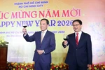 越共中央政治局委员、胡志明市市委书记陈流光（左）与各位来宾举杯共庆新年。图自越通社