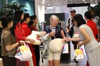向菲律宾马尼拉和印度尼西亚巴厘岛直飞岘港市的两架航班上国际游客赠送礼物。图自越通社