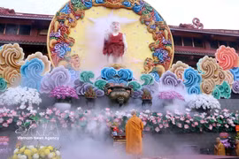 越南佛教教会法主释智广长老在佛诞像前敬香。图自越通社 