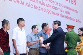 范明政与公安部、内务部领导向15位烈士家庭代表授予ADN鉴定结论通知书。图自越通社