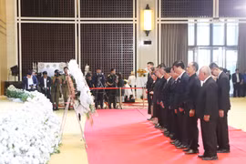 老挝越南人总会及万象市越南人协会向老挝国会主席赛宋蓬·丰威汉同志敬献花圈并默哀一分钟。图自越通社