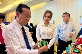 胡志明市人民委员会副主席裴明盛参观活动期间举行的创新创意产品展示活动。图自越通社