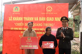 广义省西茶乡丁文郡先生在新房移交仪式上受到公安部及各组织的礼物。图自越通社