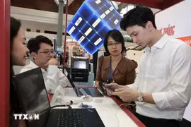 银行工作人员引导客户使用在线服务。图自越通社