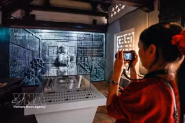 参观者参观“青史留名”展览，该展览采用传统展示形式结合数字化技术。图自越通社