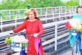 英国人斯特拉·乔拉骑自行车，宣传越南传统奥黛。图自《人民报》