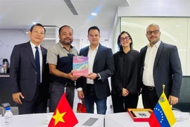 越通社驻墨西哥社长张飞雄向委内瑞拉信息传媒部副部长西蒙·阿雷奇德赠送纪念品。图自越通社