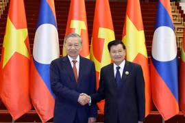 越共中央总书记苏林与老挝人民革命党中央总书记、国家主席通伦·西苏里亲切握手。图自越通社