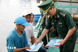 向渔民发放有关打击IUU捕捞的宣传资料。图自越通社。