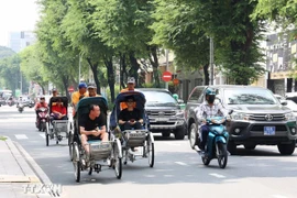 游客乘坐人力三轮车参观胡志明市中心。图自越通社