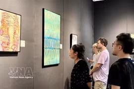 题为“本源”的绘画展上的参观者。图自越通社