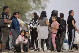 寻求庇护的移民在美国得克萨斯州伊格尔帕斯的一个检查站等待上车。 图自新华社