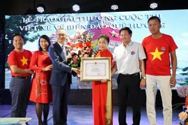 武光明大使向获奖者颁发奖状。图自越通社