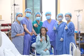 越德友谊医院的医生团队与越南首例同时实施心肺联合移植的患者合影。（医院供图）