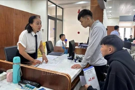 为民众办理手续。图自越通社