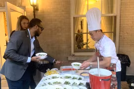 代表们在活动上品尝越南牛肉河粉。图自越通社