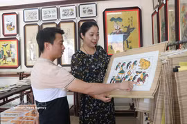 游客参观东湖民间画。图自越通社
