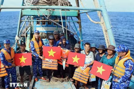 职能力量在海上向渔民赠送国旗和救生衣。图自越通社