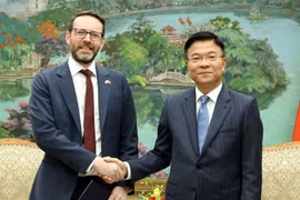 越南政府副总理黎成龙与英国驻越南特命全权大使伊恩·弗鲁亲切握手。图自越通社