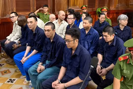 涉嫌“非法跨境运输货币罪”的14名被告出庭受审。图自劳动报