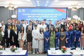 出席亮相仪式的代表们和学生们合影。图自越通社