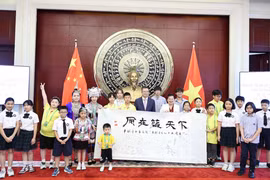范青平大使与两国少年儿童合影。图自越通社
