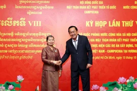 越南国防部副部长武明梁上将与柬埔寨祖国发展团结阵线国家委员会主席梅森安亲切握手。图自越通社