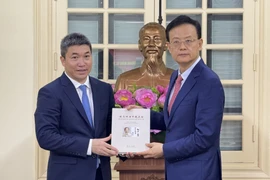 越南友好组织联合会主席潘英山（左）与广西壮族自治区外事办公室主任、对外友好协会会长魏然合影。图自越通社