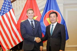越南工贸部长阮鸿延与美国负责经济增长、能源和环境事务的副国务卿雅各布·赫尔伯格。图自越通社