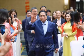 越南政府总理范明政与旅居中国越南人社群亲切会面交流。图自越通社