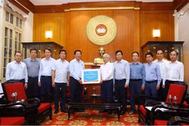 建设部领导向越南祖国阵线中央委员会主席杜文战移交捐款。图自越南妇女报