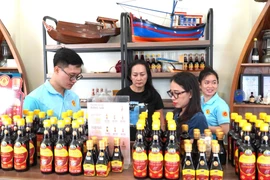 游客购买富国鱼露。图自越通社