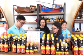 游客购买富国鱼露。图自越通社