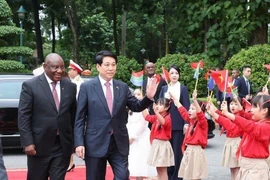 国家主席梁强与南非总统马塔梅拉·西里尔·拉马福萨向首都河内的少年儿童挥手致意。图自越通社