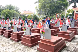 山罗省延州县延州镇（合并和两级地方政府实施前）的少年儿童与共青团员在县烈士陵园敬献香火，深切缅怀为国牺牲的英烈。图自 越通社