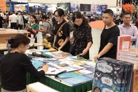 众多游客在博览会书籍展区参观。图自 越通社