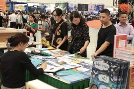 众多游客在博览会书籍展区参观。图自 越通社