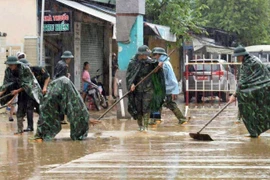 军队力量协助群众开展灾后环境清理。图自 越通社