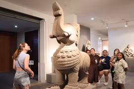 外国游客参观并了解岘港占族雕塑博物馆的文物。图自 越通社