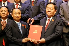 中央宣传与群众工作部部长阮仲义向蔡大玉同志授予决定。图自越通社