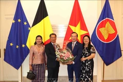 老挝驻比利时大使金福克·蓬玛哈赛向越南大使阮文草赠送鲜花。图自越通社