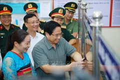 范明政总理视察清化省山区边境乡钵默行政审批工作。图自越通社