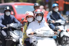 在夏天阳光强烈时外出，人们通常要戴帽子和防晒衣物。图自越通社