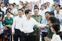 越南国家主席梁强同古芝和旭门两县选民进行接触交流。图自越通社