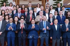 范明政总理同与会代表合影。图自越通社