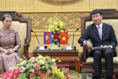 宁平省委书记陈辉俊（右）与柬埔寨祖国发展团结阵线国家委员会主席梅森安。图自越通社